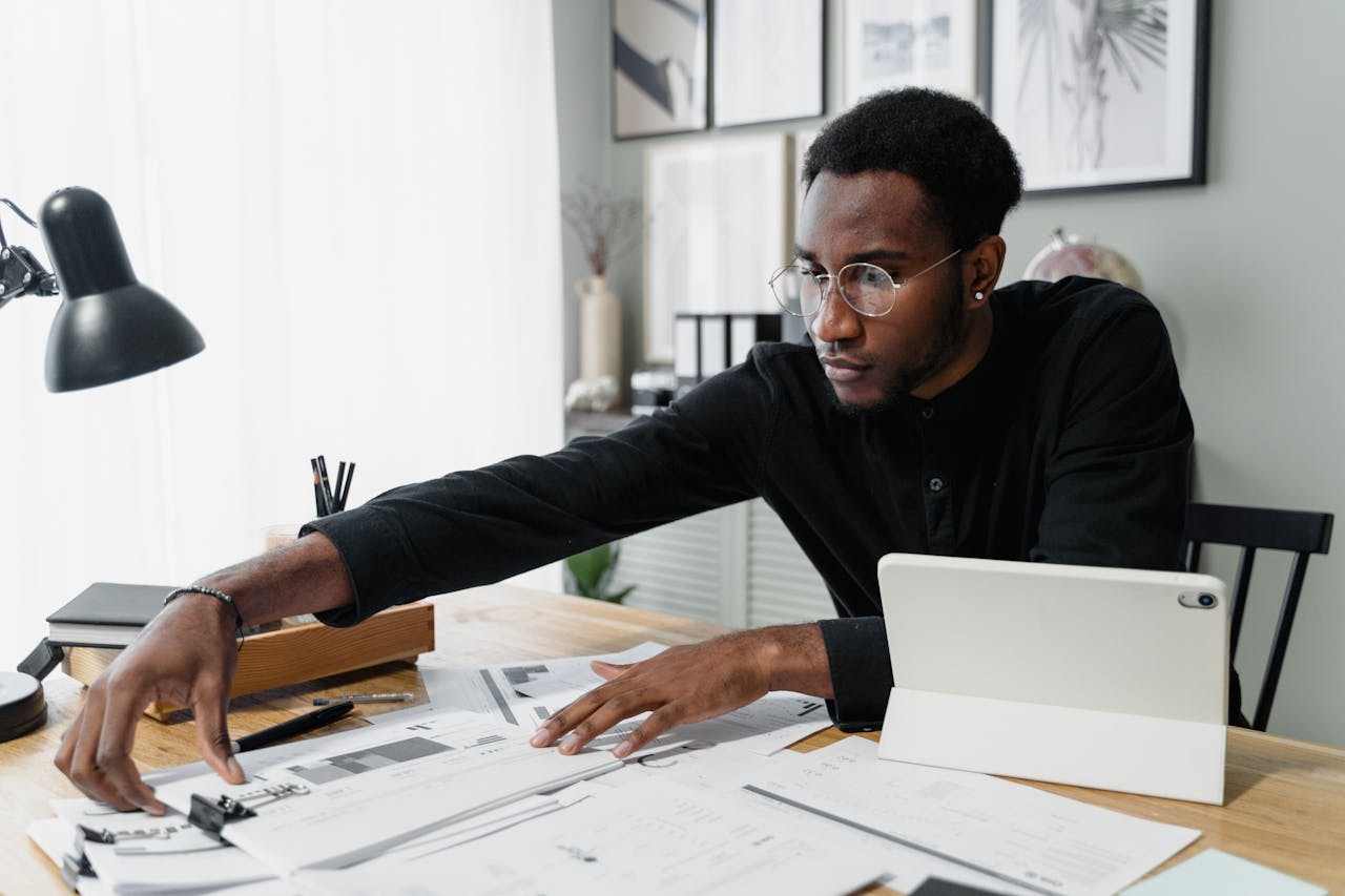 services-02 Business professional working at desk reviewing financial documents with digital tablet.